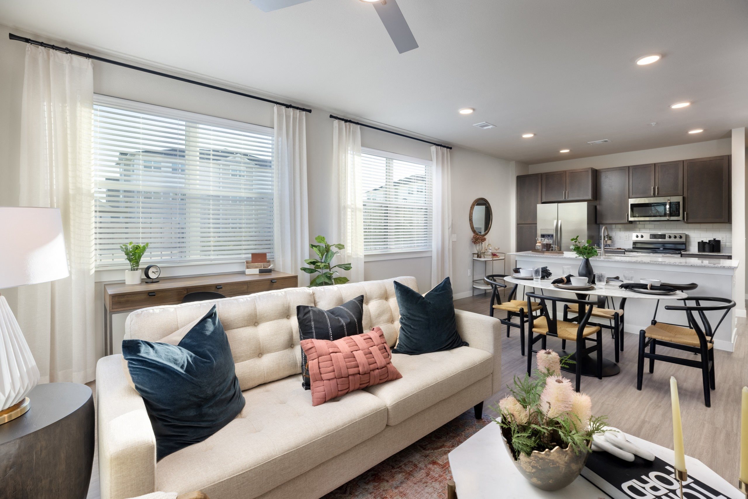 a living room with a couch and pillows in front of a kitchen